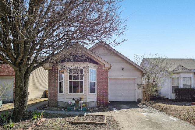 view of front of property with an attached garage, driveway, and brick siding