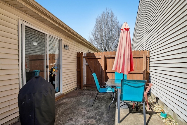 view of patio featuring a grill, fence, and outdoor dining area