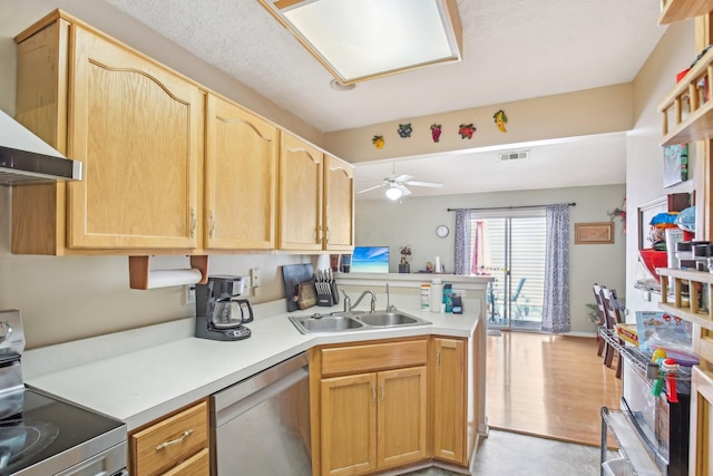 kitchen featuring light countertops, visible vents, appliances with stainless steel finishes, a sink, and a peninsula