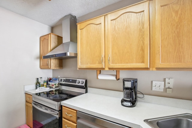 kitchen with wall chimney exhaust hood, appliances with stainless steel finishes, light countertops, and light brown cabinetry