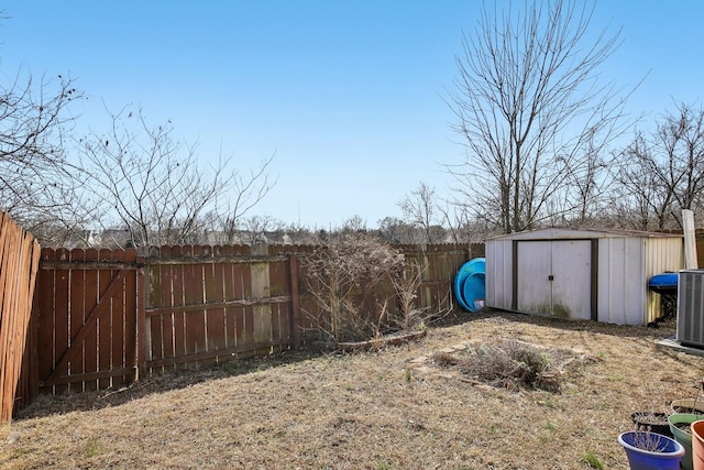 view of yard featuring cooling unit, a fenced backyard, an outdoor structure, and a storage unit