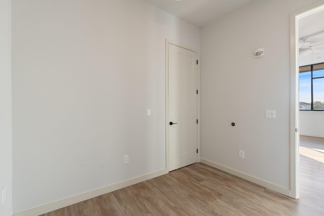 spare room featuring light wood finished floors and baseboards