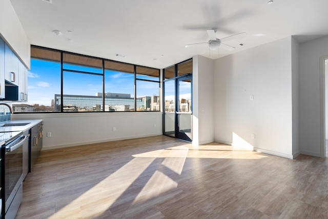 kitchen with a view of city, light wood finished floors, modern cabinets, and baseboards