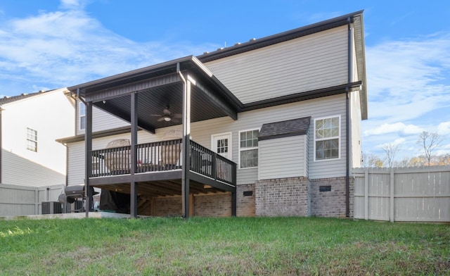 back of property with fence, a deck, central AC, and a yard