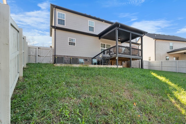 back of property with a deck, a fenced backyard, stairs, a lawn, and a gate