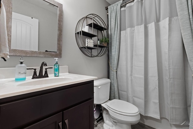 full bathroom featuring a shower with shower curtain, vanity, and toilet