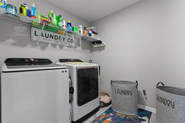 clothes washing area featuring baseboards, laundry area, tile patterned floors, and washer and dryer