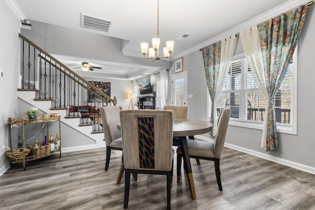 dining space with wood finished floors, visible vents, baseboards, stairs, and ornamental molding