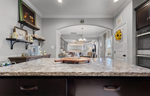 kitchen with crown molding, arched walkways, a chandelier, and dark brown cabinetry