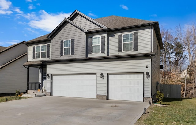 view of front facade with a garage, a front yard, concrete driveway, and roof with shingles