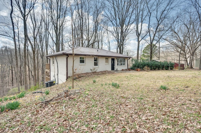 back of house featuring fence, a yard, cooling unit, and brick siding