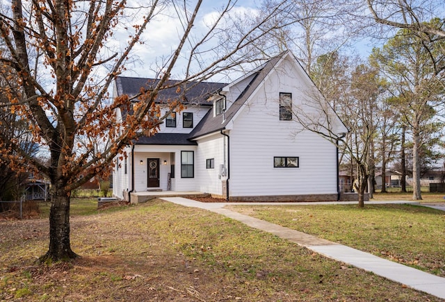 view of front of house with a front lawn and roof with shingles