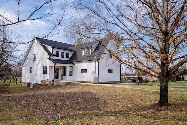 view of front of house with a front lawn and roof with shingles