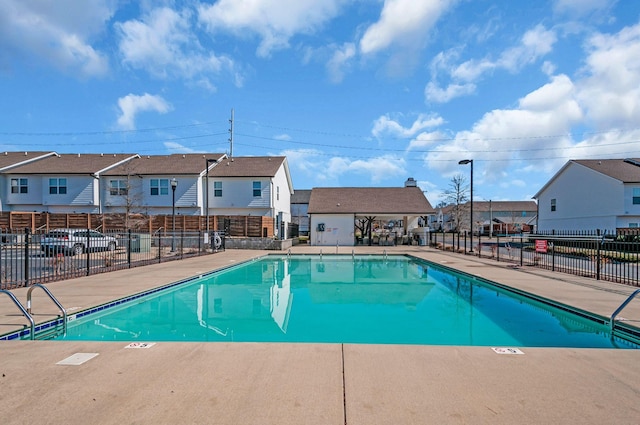 community pool with a residential view and fence