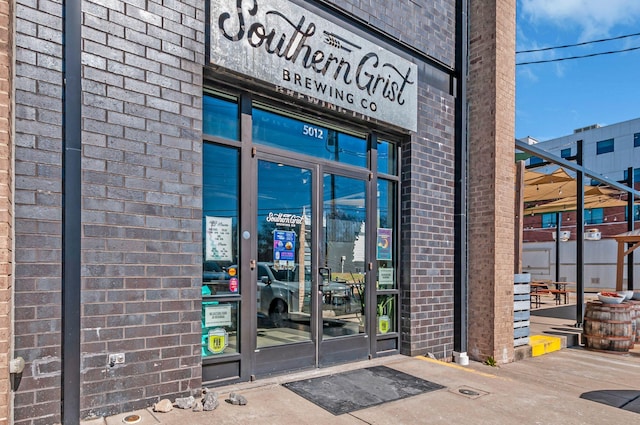 entrance to property featuring brick siding