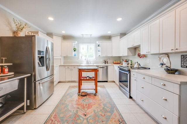 kitchen with crown molding, stainless steel appliances, light countertops, white cabinetry, and a sink