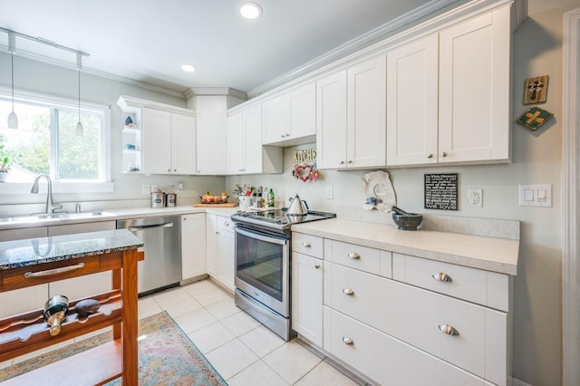 kitchen featuring appliances with stainless steel finishes, light countertops, white cabinetry, and a sink