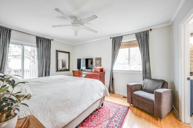 bedroom featuring a ceiling fan, light wood-type flooring, multiple windows, and crown molding