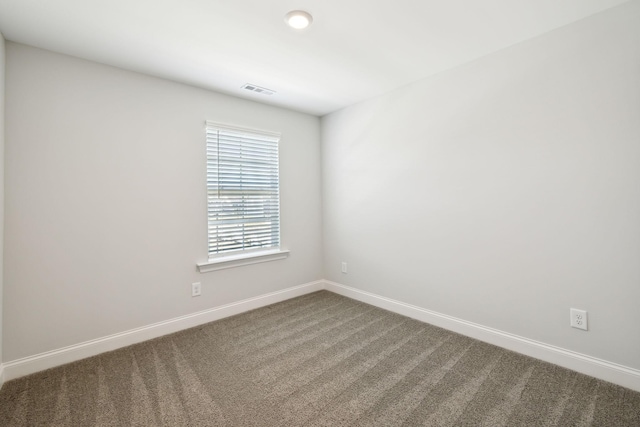 empty room featuring visible vents, baseboards, and carpet flooring