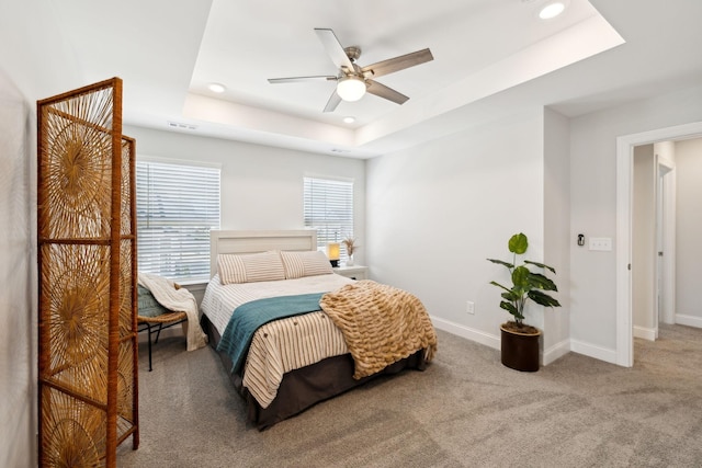 bedroom featuring a tray ceiling, carpet, recessed lighting, visible vents, and baseboards