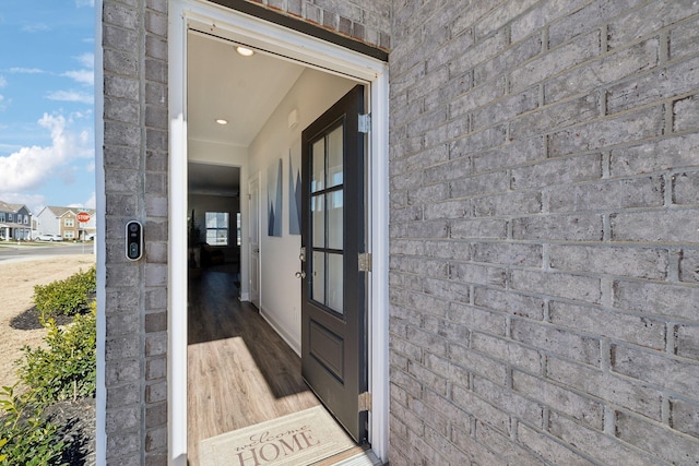 view of exterior entry featuring brick siding