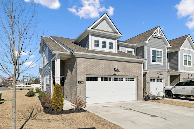 view of home's exterior with an attached garage, brick siding, fence, driveway, and board and batten siding