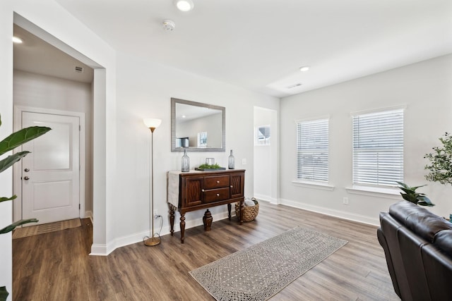 sitting room with baseboards, wood finished floors, and recessed lighting