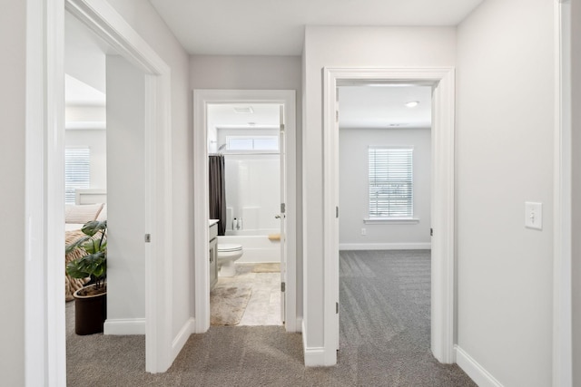 hallway with light carpet and baseboards