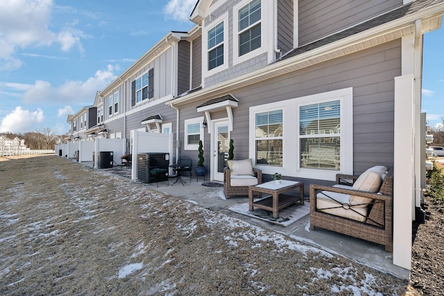 exterior space with cooling unit, fence, and a residential view