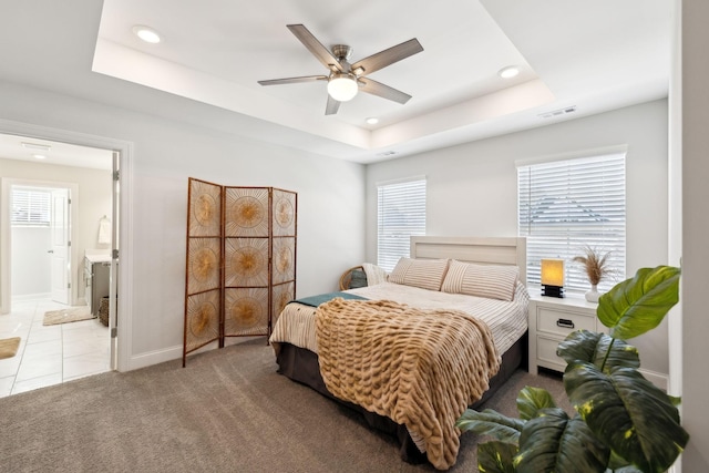 bedroom featuring light carpet, baseboards, a tray ceiling, and recessed lighting