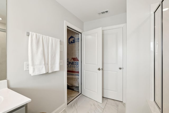 bathroom with marble finish floor, vanity, and visible vents