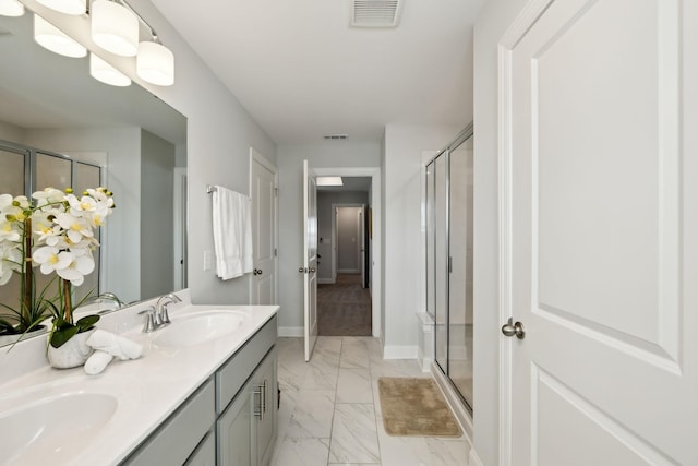 bathroom with a stall shower, baseboards, visible vents, marble finish floor, and a sink