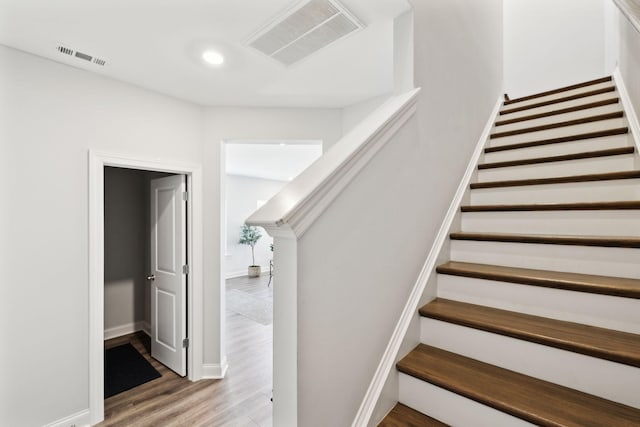 stairs featuring baseboards, wood finished floors, visible vents, and recessed lighting