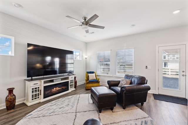 living room with wood finished floors, a ceiling fan, and baseboards