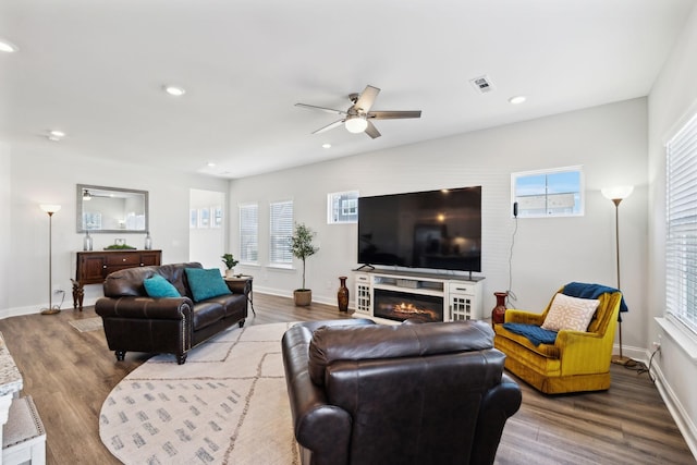 living room featuring a healthy amount of sunlight, visible vents, wood finished floors, and recessed lighting