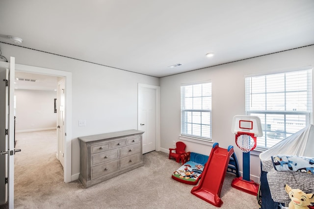 recreation room with baseboards, visible vents, and light colored carpet