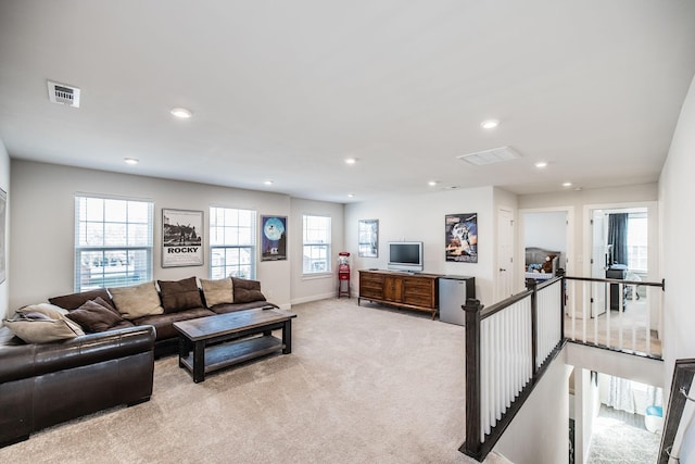 living area with recessed lighting, visible vents, light carpet, and baseboards