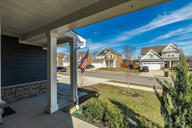 view of yard featuring covered porch and a residential view