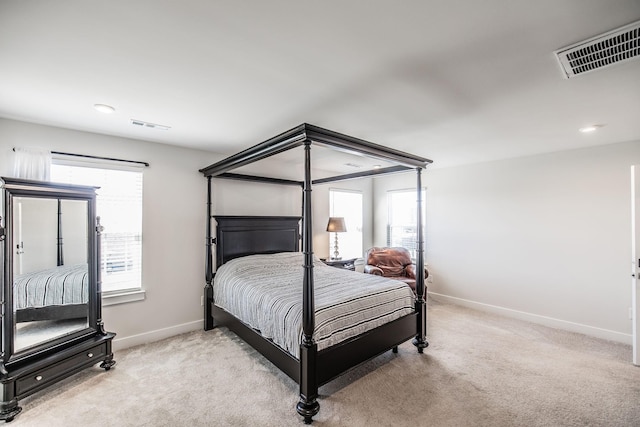 bedroom featuring light carpet, baseboards, multiple windows, and visible vents