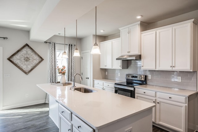 kitchen featuring light countertops, under cabinet range hood, an island with sink, and stainless steel electric stove