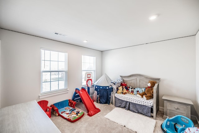 carpeted bedroom featuring visible vents