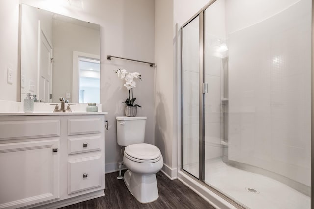 bathroom with vanity, wood finished floors, a shower stall, and toilet