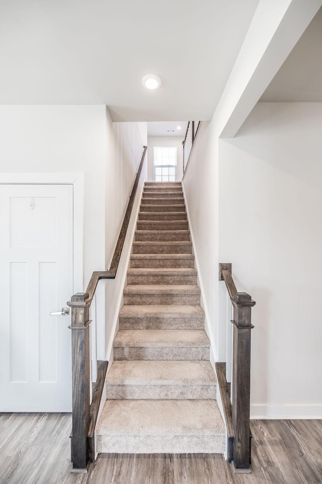 staircase with wood finished floors and baseboards