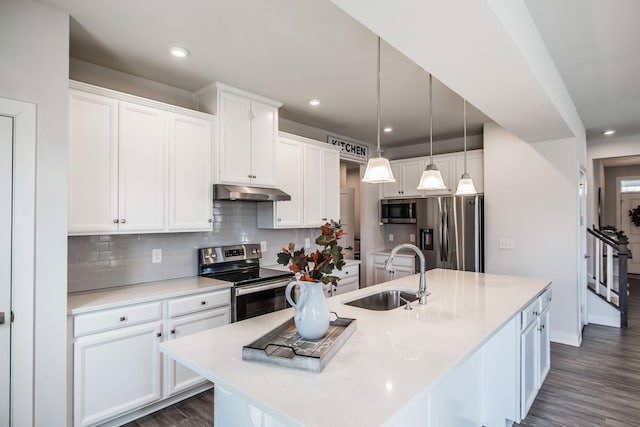 kitchen featuring stainless steel appliances, light countertops, a sink, and white cabinetry