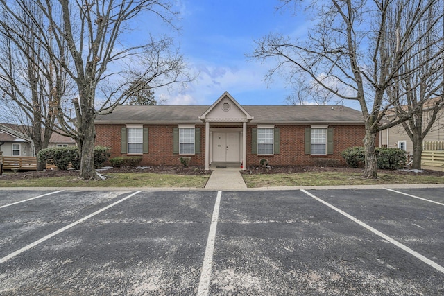 view of front of house featuring uncovered parking and brick siding