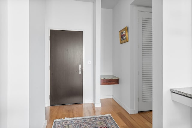 foyer entrance with light wood-type flooring and baseboards