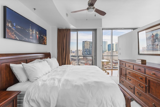 bedroom with a view of city, a ceiling fan, and access to exterior