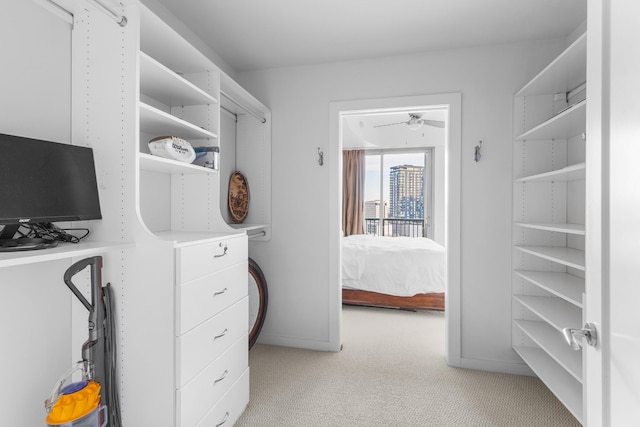 spacious closet with light carpet and ceiling fan