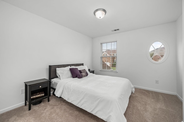 bedroom featuring visible vents, light carpet, and baseboards