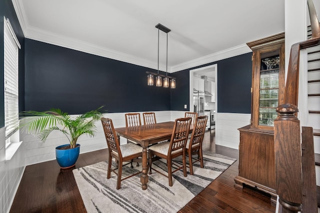 dining area featuring wainscoting, wood finished floors, and crown molding